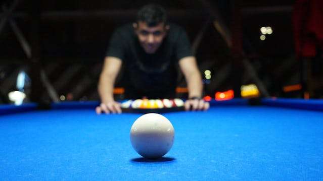 guy staring at white billard ball